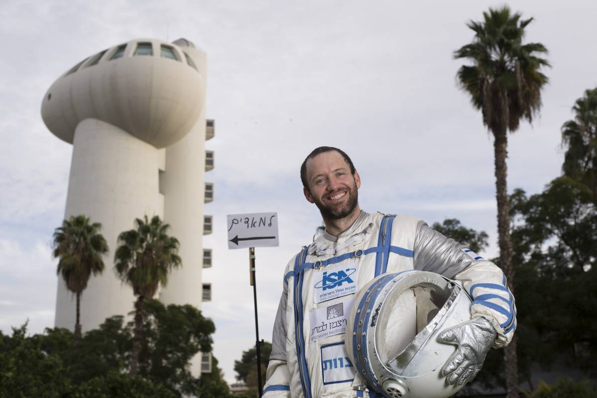Roy Naor next to a sign in Hebrew which reads "To Mars". Courtesy
