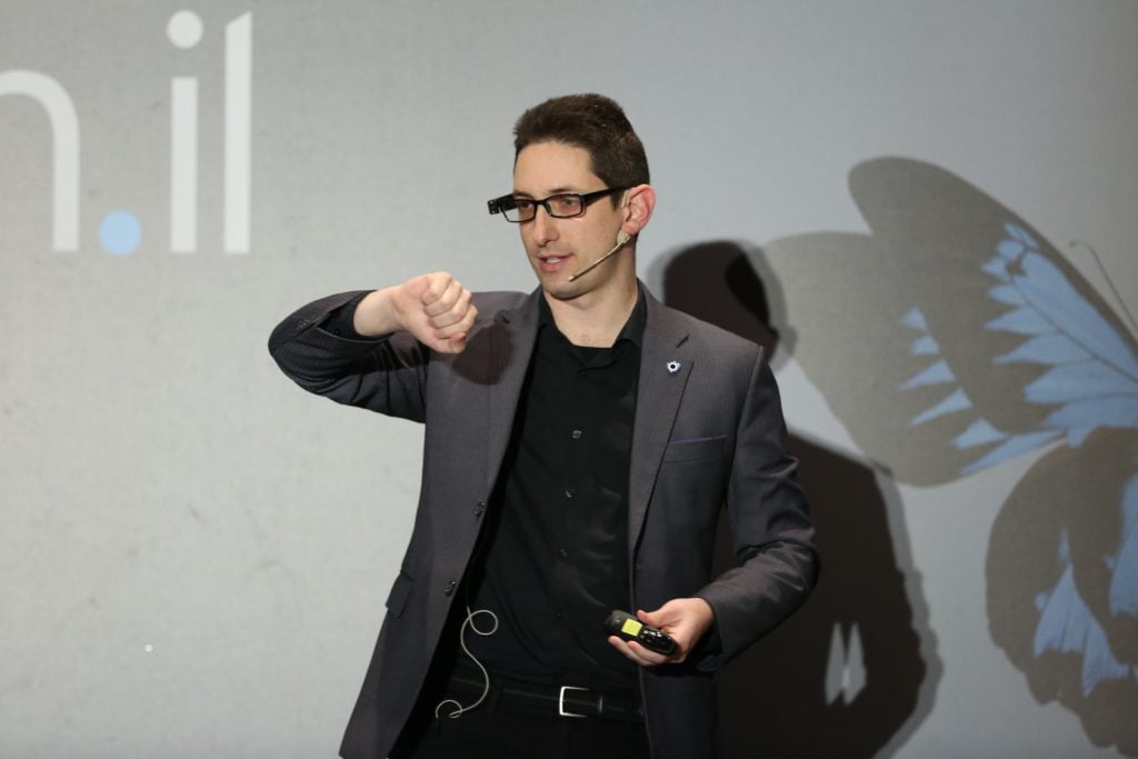 Eliav Rodman is not wearing a watch, but the OrCam MyEye attached to his glasses recognizes his wrist and tells him the time, At the Digital Health IL conference in Tel Aviv on January 23, 2018. Photo by Shauli Landner