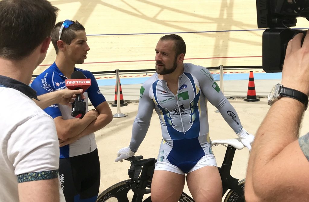 Journalists interview German track cyclist Robert Förstemann, center, and Israel Cycling Academy's Roy Goldstein at the Velodrome in Tel Aviv, May 1, 2018. Photo by Viva Sarah Press