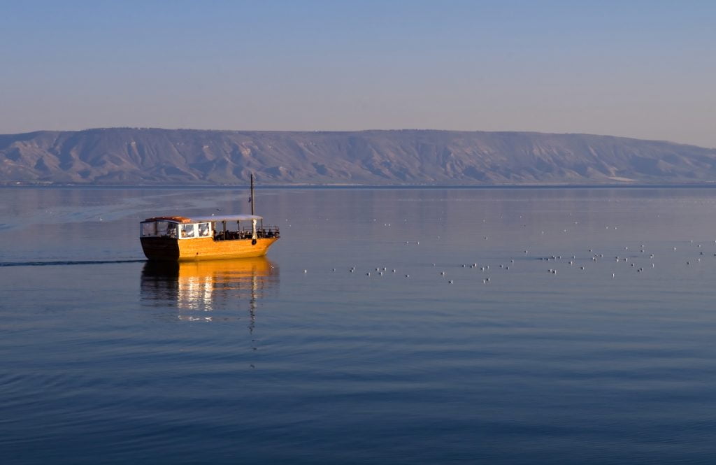 A boat floats on the Sea of Galilee . <a href="https://depositphotos.com/stock-photos/sea-of-galilee.html?filter=all&qview=9569778" target="_blank" rel=