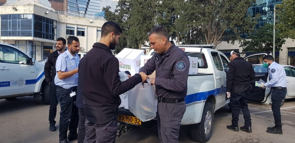 Volunteers and city patrolers distribute aid packages in Tel Aviv. Courtesy