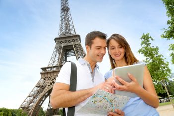 Tourists using an iPad in front of the Eiffel tower via BigStock
