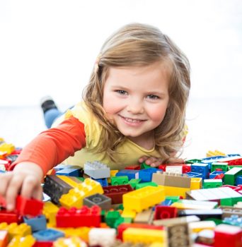 Girl playing with Lego via Lego's Website