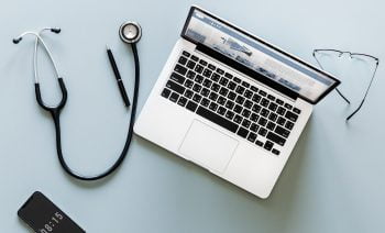 A stethoscope near a laptop. Pixabay