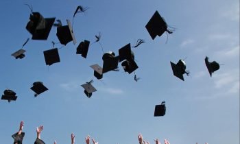 Graduation caps in the air. Illustrative photo by Pexels