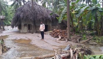 A man standing outside a home near Malampuzha Dam in Kerala, India. Photo via Flickr