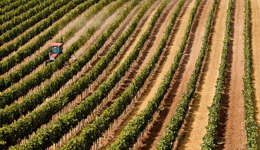 A tractor in an agricultural field. Photo via Deposit Photos