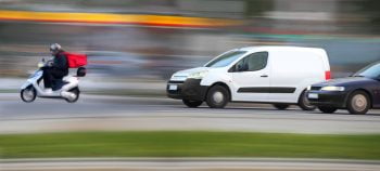 An illustrative photo of a delivery van and a delivery scooter. Deposit Photos