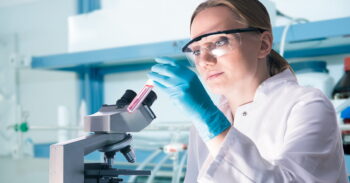 An illustrative photo of a scientist working in a lab. Photo by alexraths / Deposit Photos