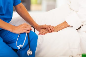 An illustrative photo of a doctor holding a patient's hand. Deposit Photos