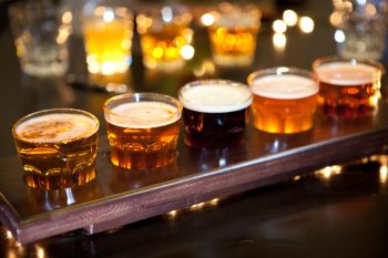 Illustrative photo of glasses of different beers on a pub background. Deposit Photos