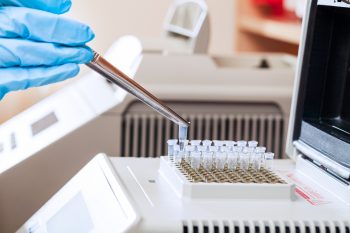 A technician loading test tubes with sampled DNA for polymerase chain reaction. Illustrative. Deposit Photos