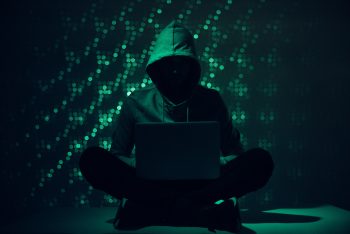 An illustrative photo depicting a hacker.. Deposit Photos