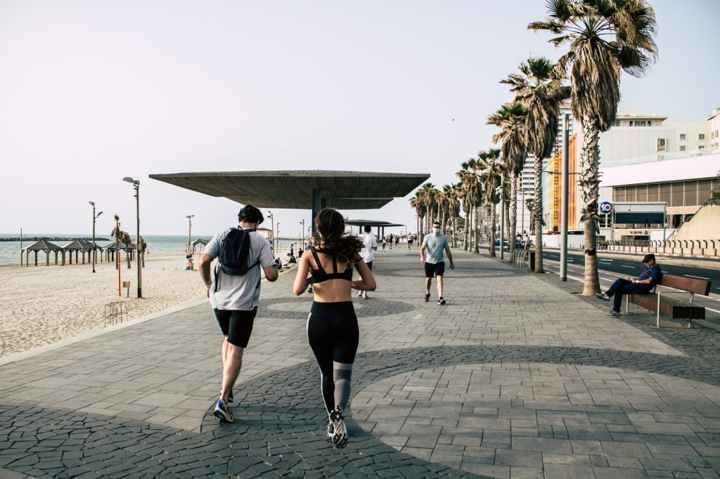 Joggers on the Tel Aviv promenade in April 2020 during the global pandemic. Deposit Photos