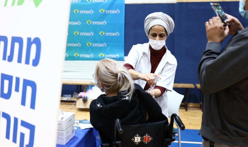 A nurse vaccinates a woman for COVID-19, in central Israel, December 28, 2020. Photo: Gideon Sharon/ GPO