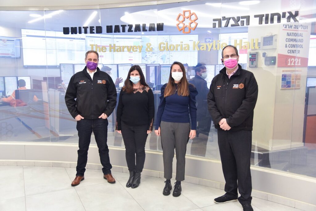 Nanosynex co-founders Michelle Heymann and Diane Abensur Bessin stand between Dov Maisel and Eli Beer from United Hatzalah outside the national dispatch center. Courtesy
