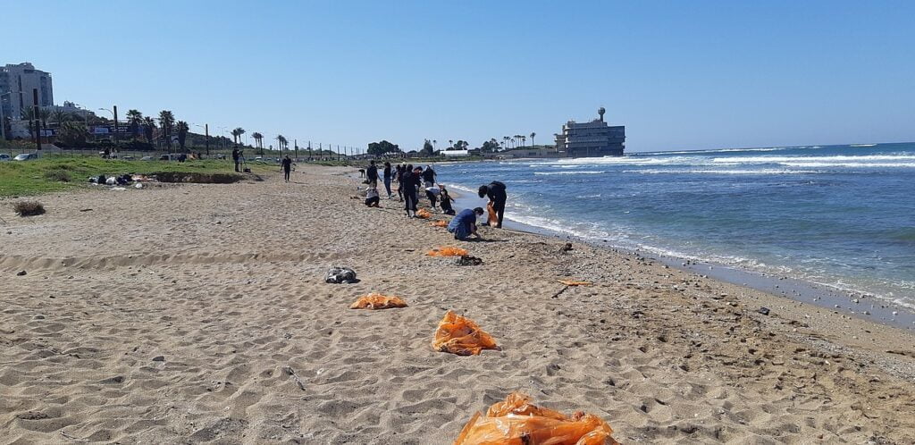 Volunteers clean up tar on a beach in Haifa on Friday, February 26, 2021.By Hanay - Own work, CC BY-SA 3.0.